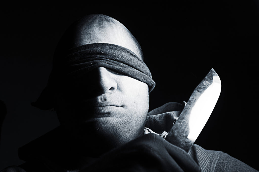 blind folded man with knife